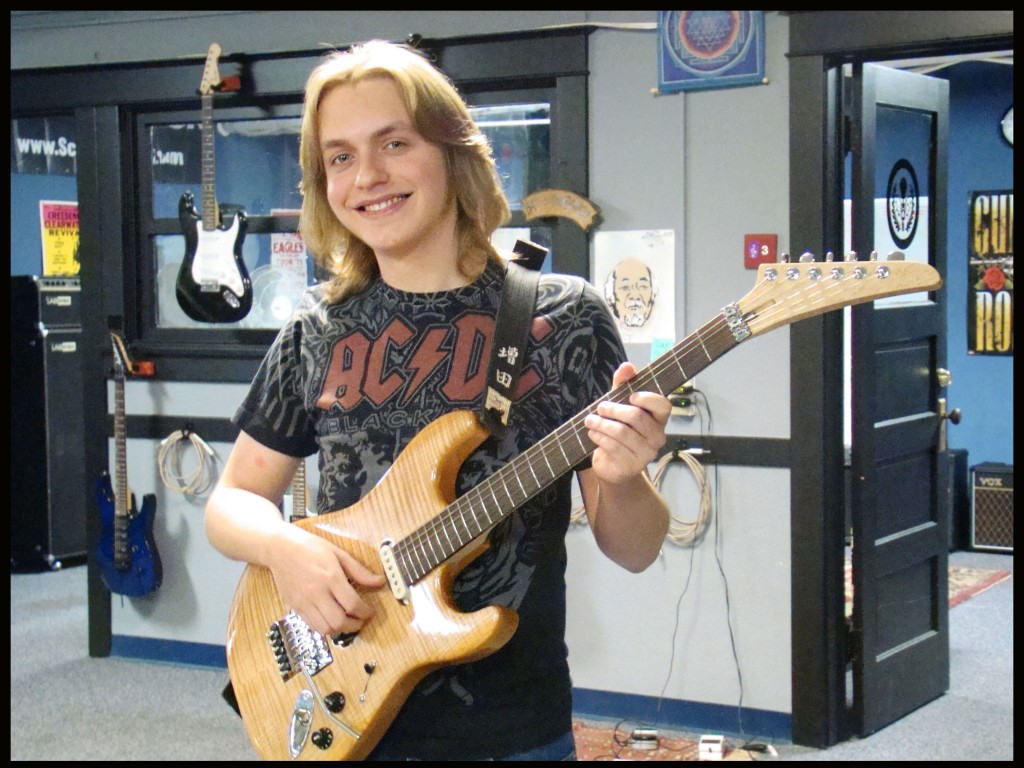 Walker Masuda holding a guitar