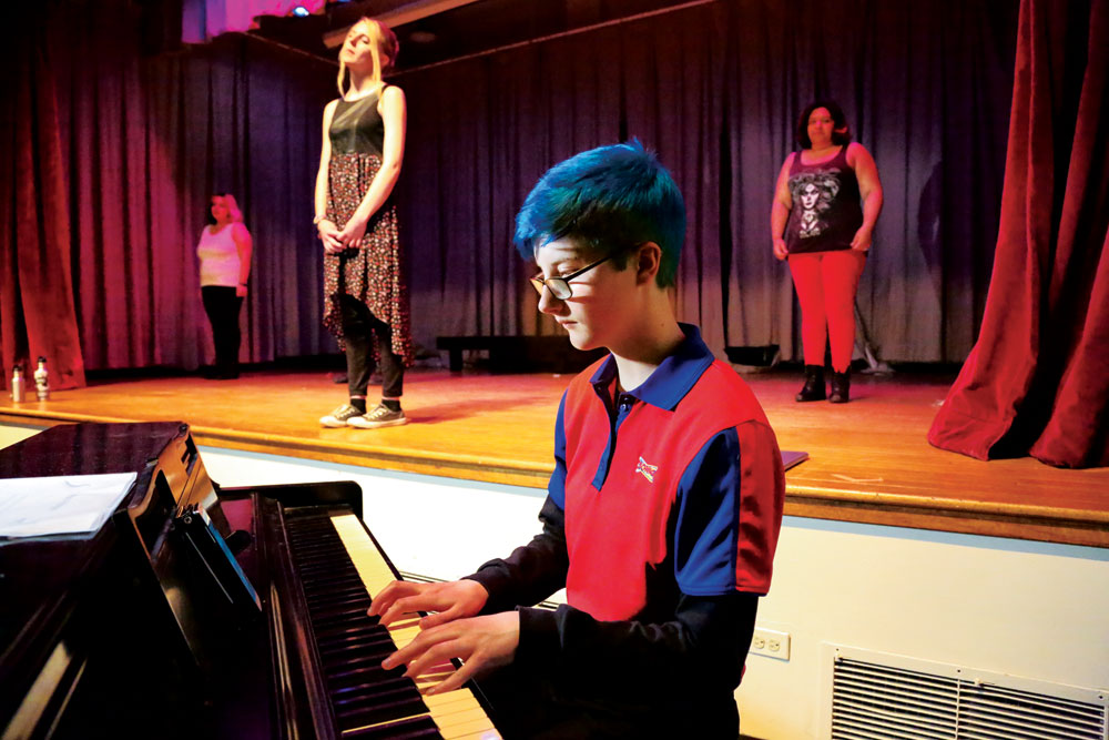 Student playing the piano at a performance